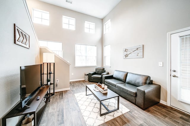 Sofa armchair coffee table rug TV stand living room at The Letterman Greensboro in Greensboro Student Accommodation