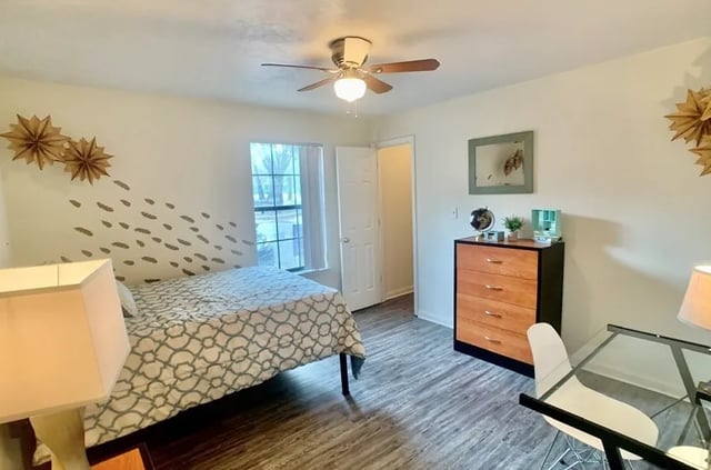 Bed dresser desk and lamp bedroom interior at Bradford Oaks Apartments in Tallahassee Student Accommodation