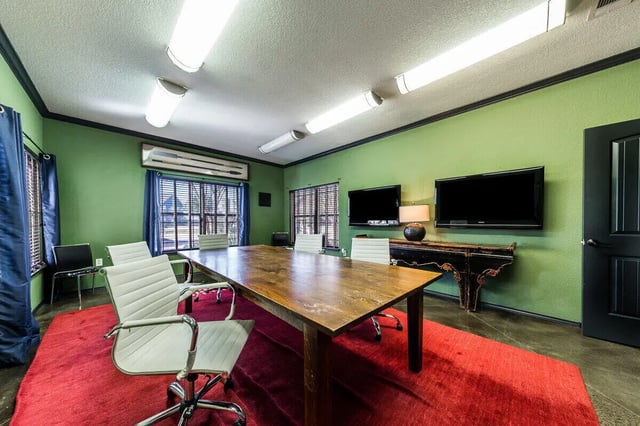 Large table chairs televisions and red rug study area at The Reserve at College Station in College Station Student Accommodation