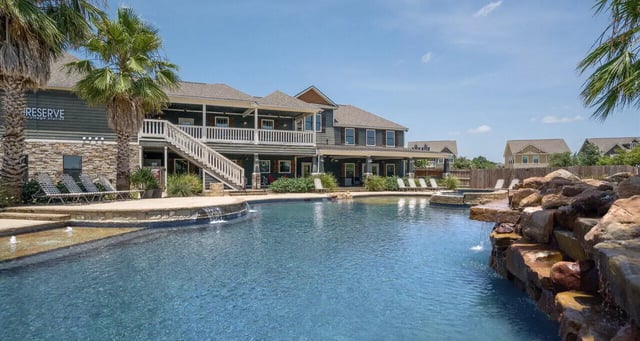 Resort style pool with rock waterfall and lounge chairs exterior at The Reserve at College Station in College Station Student Accommodation