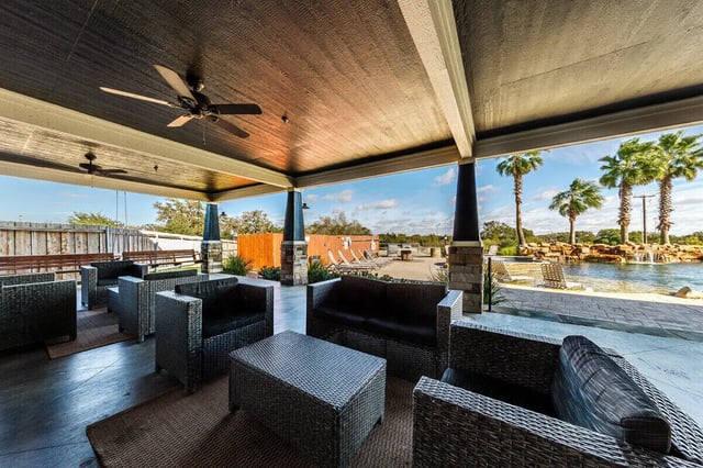 Wicker seating and tables by pool exterior at The Reserve at College Station in College Station Student Accommodation