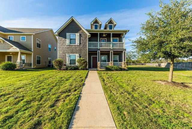 Two story duplex with porch swing exterior at The Reserve at College Station in College Station Student Accommodation