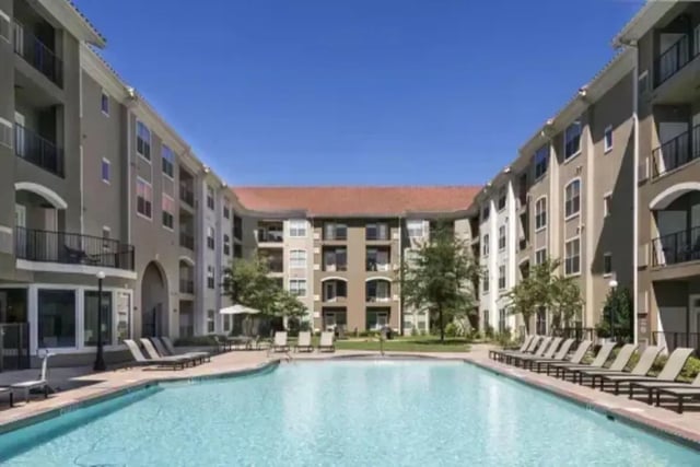 Apartment buildings surrounding a swimming pool and lounge chairs exterior at The Centre Suites in Lubbock Student Accommodation