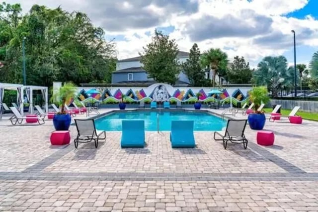 Pool lounge chairs colorful mural courtyard pool exterior at Arden Villas in Orlando Student Accommodation