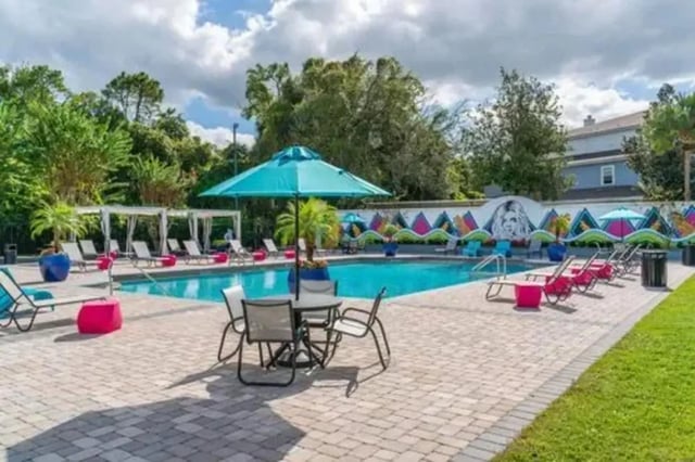 Poolside lounge chairs tables umbrellas and murals exterior at Arden Villas in Orlando Student Accommodation