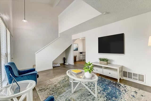 Blue chairs TV and stairs living room at The Lights Apartments in Denton Student Accommodation