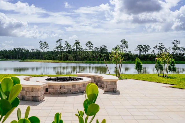 Fire pit and curved bench overlooking lake outdoor area at The Residences at University Village in Fort Myers Student Accommodation