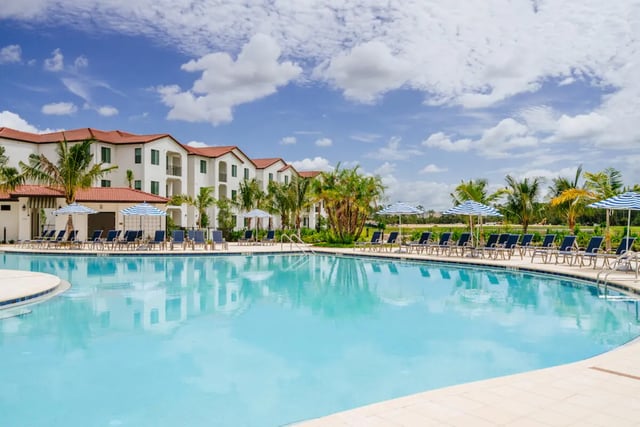 Pool lounge chairs building exterior at The Residences at University Village in Fort Myers Student Accommodation