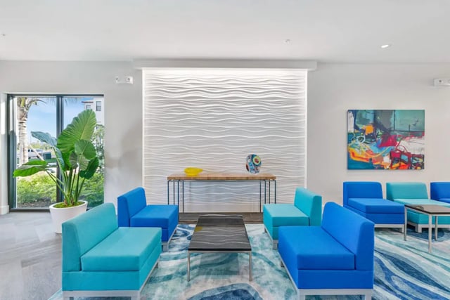 Blue and teal couches modern table abstract painting common area at The Residences at University Village in Fort Myers Student Accommodation