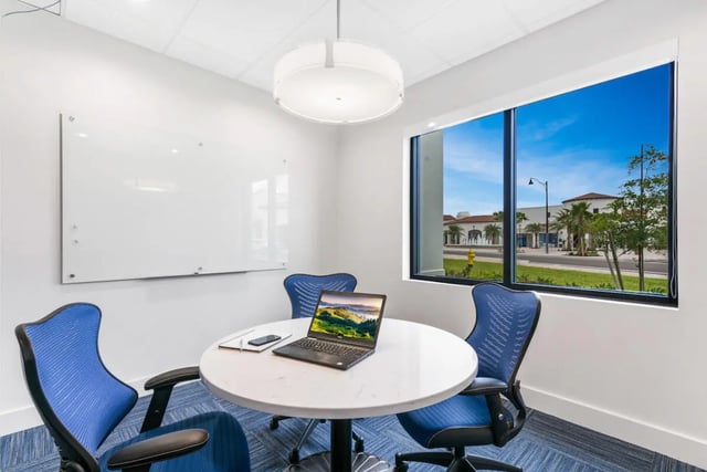 Round table laptop chairs whiteboard meeting room at The Residences at University Village in Fort Myers Student Accommodation