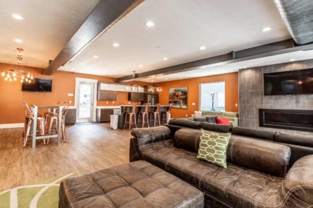Leather sofas kitchen bar stools fireplace living room at CollegePlace Provo in Provo Student Accommodation