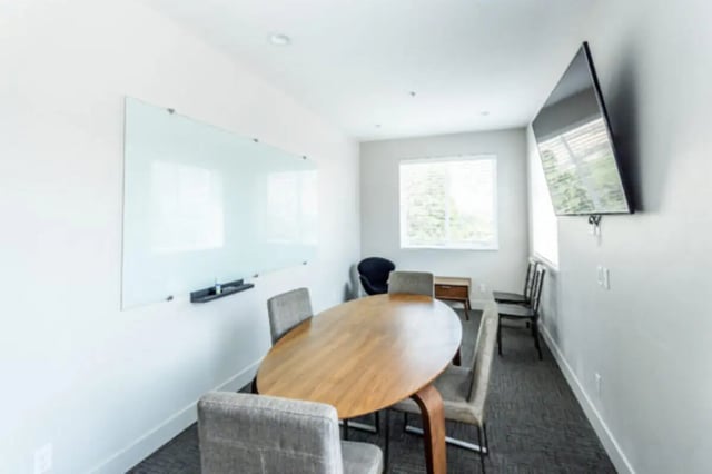 Oval table four chairs whiteboard television study area at CollegePlace Provo in Provo Student Accommodation