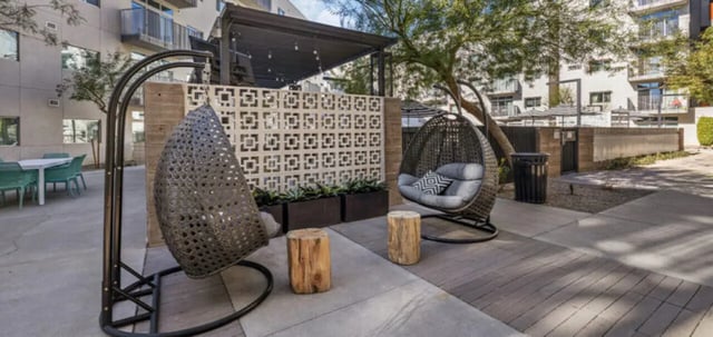 Wicker egg chairs with wooden stools outdoor living area at Vertex Apartments in Tallahassee Student Accommodation