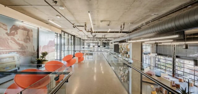Orange chairs large windows concrete ceiling common area at The Vista in Turlock Student Accommodation