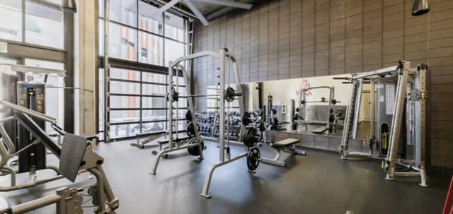 Gym with weight machines and dumbbells Fitness center at The Vista in Turlock Student Accommodation
