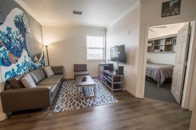 Sofa coffee table television and bed living room bedroom at CollegePlace Uptown