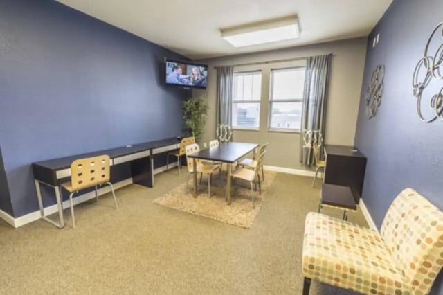 Desks dining table chairs and TV common area at CollegePlace Uptown