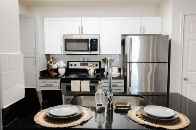 Stainless steel appliances and white cabinets kitchen at The Lodge Apartments in San Marcos Student Accommodation