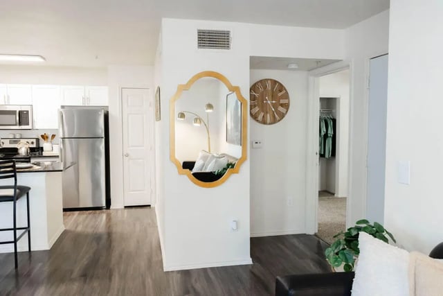 Kitchen stainless steel refrigerator and living room living room at The Lodge Apartments in San Marcos Student Accommodation
