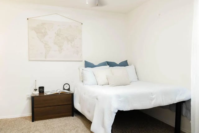 World map and bedside table bedroom at The Lodge Apartments in San Marcos Student Accommodation