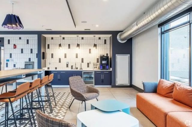 Kitchen with bar stools couch and coffee machine kitchen at Vic Village South in Ann Arbor Student Accommodation