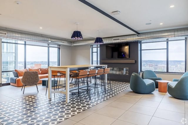 Orange sofa bar stools long table modern lounge area at Vic Village South in Ann Arbor Student Accommodation