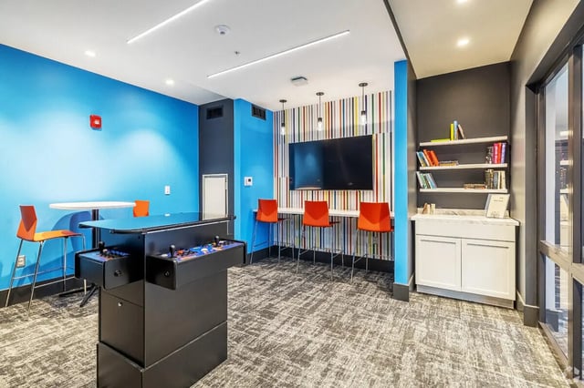 Arcade game table TV and bar stools common area at Vic Village South in Ann Arbor Student Accommodation