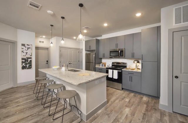 Island with stools and grey cabinets kitchen at The Wyatt in Lubbock Student Accommodation