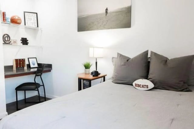 Bed pillows football desk chair study area bedroom at Villagio Apartments in San Marcos Student Accommodation
