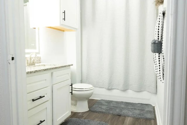 White vanity toilet white shower curtain bathroom at Villagio Apartments in San Marcos Student Accommodation