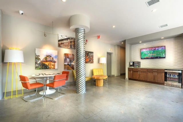 Four orange chairs at table living room at Villas on 26th in Austin Student Accommodation