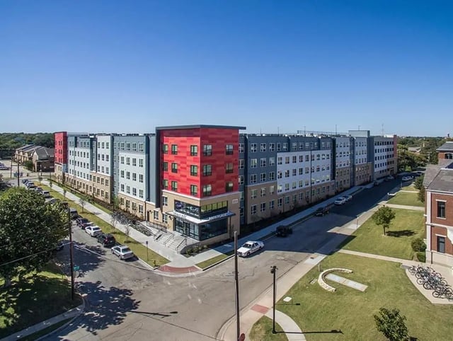 Modern apartment building with red and gray exterior exterior at Park Place Waco in Waco Student Accommodation