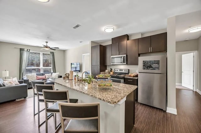Granite island stools sofa and living area kitchen at Park Place Waco in Waco Student Accommodation