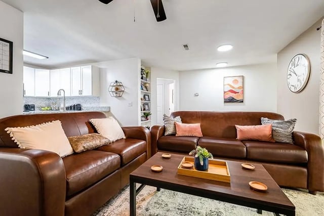 Leather couches coffee table with plants living room at The Hills Northview Apartments in Harrisonburg Student Accommodation