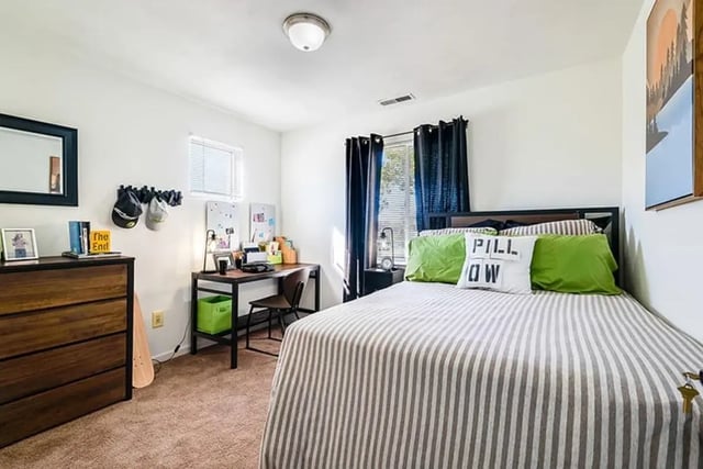 Bed dresser desk and skateboard bedroom at The Hills Northview Apartments in Harrisonburg Student Accommodation