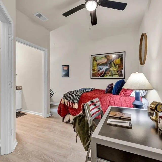 Bed desk chair lamp with artwork bedroom at The Luxe on West Call in Tallahassee Student Accommodation