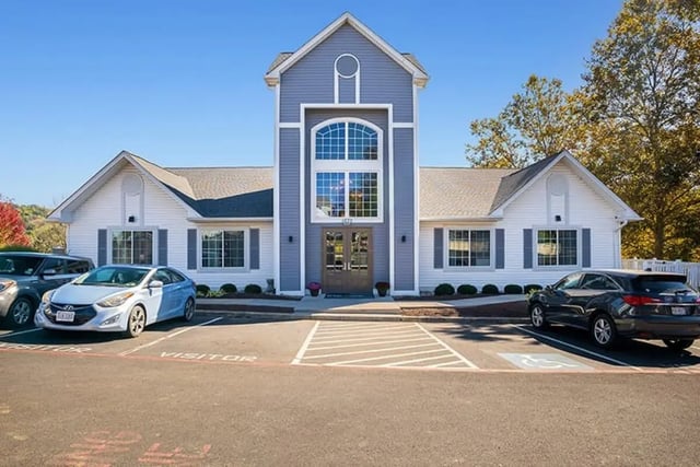 Property exterior with blue and white building and cars exterior at The Hills Southview Apartments in Harrisonburg Student Accommodation