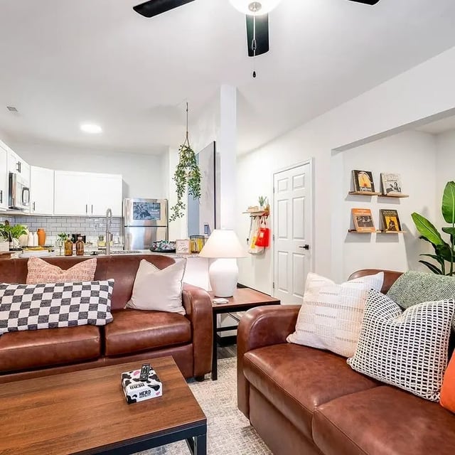 Brown sofas with patterned pillows kitchen living room at The Hills Southview Apartments in Harrisonburg Student Accommodation