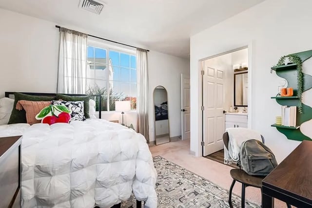 Bed pillows rug door bathroom mirror bedroom at The Hills Southview Apartments in Harrisonburg Student Accommodation