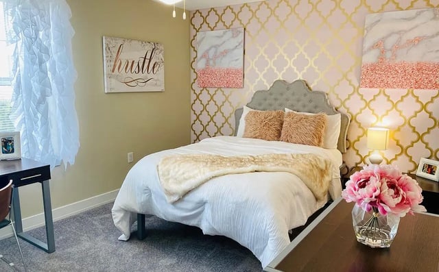 Bed with plush pillows desk and flowers Bedroom at The Avenue at San Marcos in San Marcos Student Accommodation