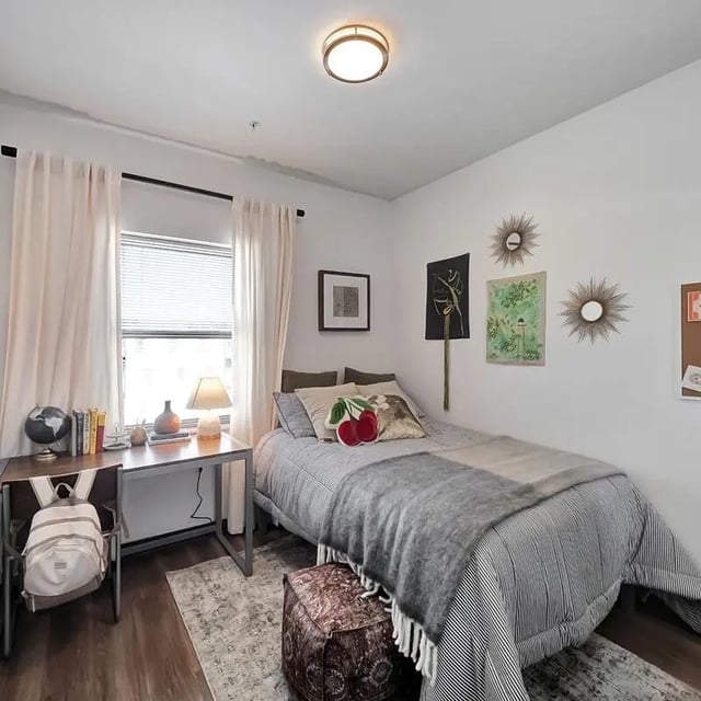 Bed with desk backpack and globe bedroom at The Rowe Apartments in Tallahassee Student Accommodation