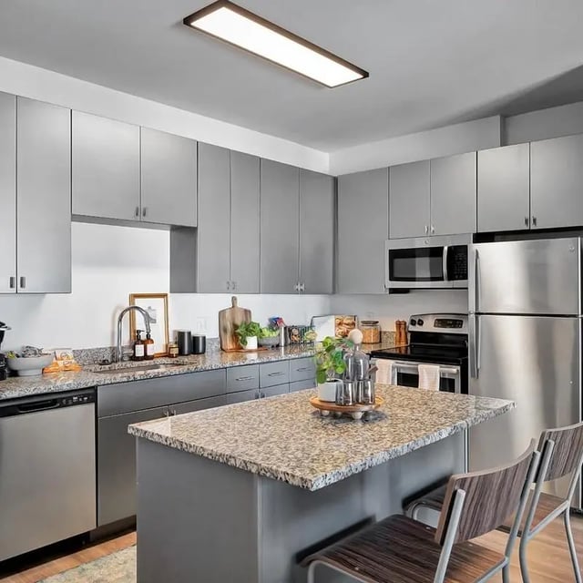 Modern gray kitchen with island and appliances kitchen at The Rowe Apartments in Tallahassee Student Accommodation