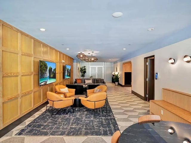 Orange chairs and TVs in living room at The Rowe Apartments in Tallahassee Student Accommodation