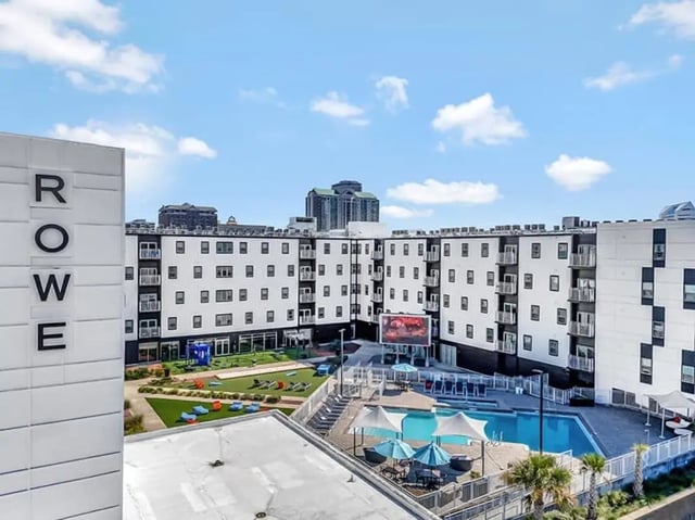 Apartment building with pool and green space exterior at The Rowe Apartments in Tallahassee Student Accommodation