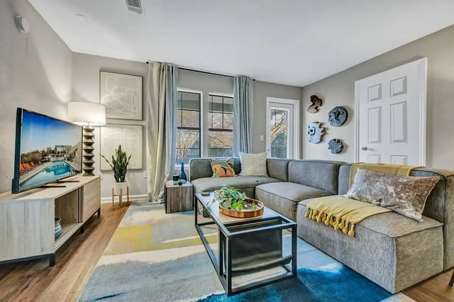 Modern living room with sectional couch and TV living room at The Wilde Raleigh Apartments in Raleigh Student Accommodation