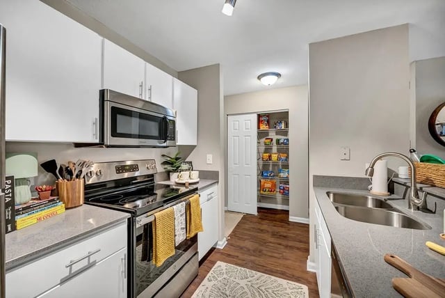 White cabinets microwave stove pantry stocked kitchen at The Wilde Raleigh Apartments in Raleigh Student Accommodation