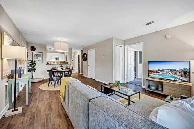 Grey sofa TV dining table living room at The Wilde Raleigh Apartments in Raleigh Student Accommodation