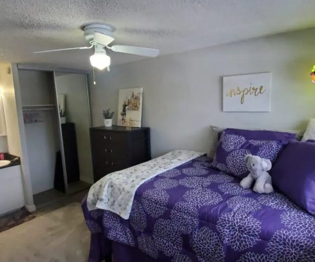 Purple floral bedding dresser mirror ceiling fan bedroom at Capri Eugene Apartments in Eugene Student Accommodation