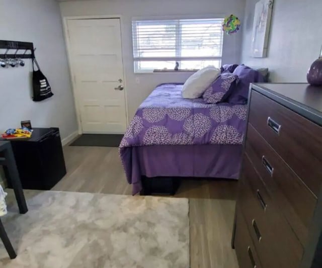 Purple patterned bed white door dresser bedroom at Capri Eugene Apartments in Eugene Student Accommodation