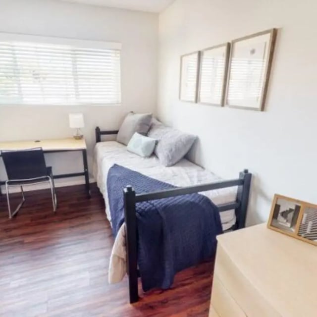 Bed desk chair and framed art bedroom at Capri at Isla Vista Apartments in Isla Vista Student Accommodation